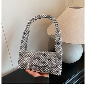 Detail of silver beaded handbag showing intricate acrylic woven texture and metal finish