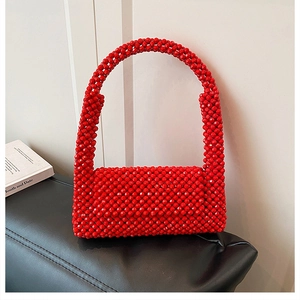 Detail of red acrylic beaded woven handbag showing intricate texture and handmade craft