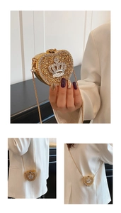 Detail of heart evening clutch with gold crystals, crown emblem and metal chain