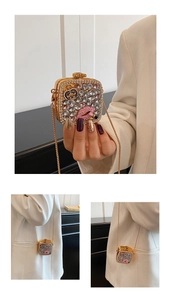 Detailed close-up of a mini crystal square evening bag with pink lip motif and gold chain