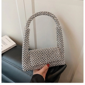 Detailed view of handcrafted silver acrylic beaded weaving on a luxury evening handbag