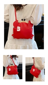Detailed view of creative red crab crossbody bag with metal frame and clip closure