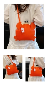 Detailed macro view of orange crab shaped crossbody bag with vintage metal clasp closure