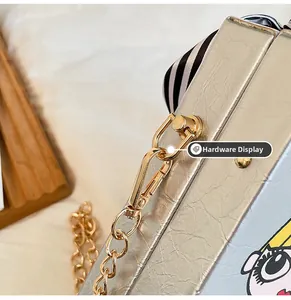 Detailed macro view of high-gloss gold hardware and hinges on a silver box evening bag