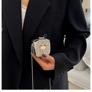 Detailed macro view of a silver rhinestone evening bag with a unique fox head ornament
