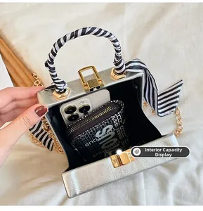 Silver box clutch interior view showing space for a smartphone and chain strap detail