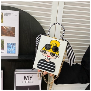 Detailed view of the structured box bag featuring a cartoon girl print and silk scarf handle