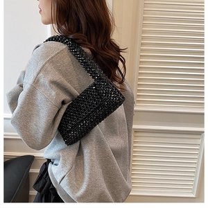 Detail shot of a black acrylic beaded shoulder bag featuring a unique woven texture