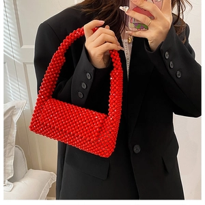 Detail view of a handmade red acrylic beaded handbag with reflective glossy texture