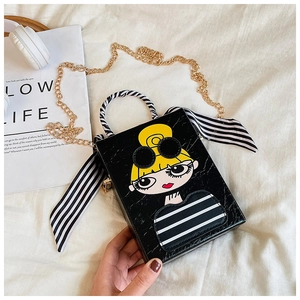 Detail of black faux crocodile leather crossbody bag with cartoon girl and silk scarf handle