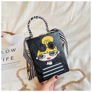Detail of a black crossbody box bag with fashion girl print and silk scarf handle