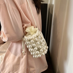 Elegant white pearl woven crossbody bag with satin drawstring and long shoulder strap