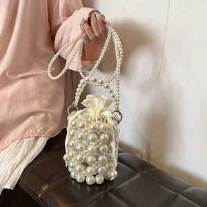 Elegant ivory woven pearl bucket bag with drawstring liner and dual pearl chain straps
