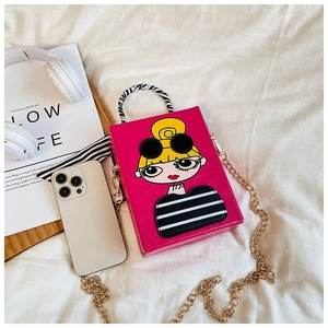Close-up of fuchsia box bag with cartoon girl print and zebra handle on white fabric