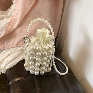 Elegant white pearl woven bucket bag with satin drawstring liner and pearl shoulder strap