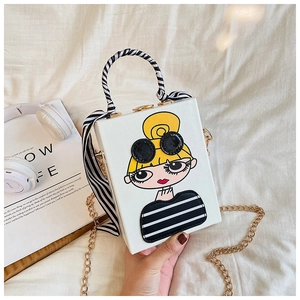 Detail of white box bag featuring cartoon girl print and silk scarf wrapped handle