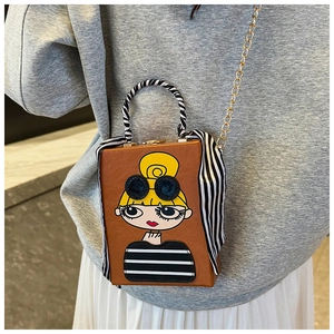 Detail of a brown leather box bag with a cartoon girl print and stripe scarf handle