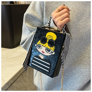 Detail of a black box clutch with cartoon girl print and striped scarf handle