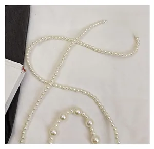 Close-up of handmade white faux pearl bag strap with large decorative pearl accents