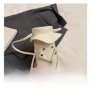 Detail of white mini cylindrical crossbody bag with motorcycle jacket design elements