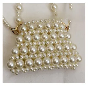 Detail of handcrafted cream pearl woven bag featuring textured hollow beads and strap