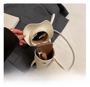 Detail showing internal capacity of the mini off-white hat-shaped PU leather crossbody bag