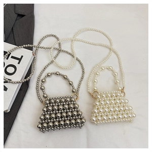Détail du mini sac tissé en perles avec des accents métalliques argentés et blancs