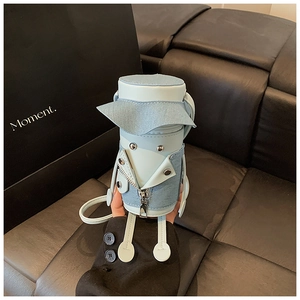 Close-up of a creative doll-shaped mini crossbody bag with denim jacket and leather details