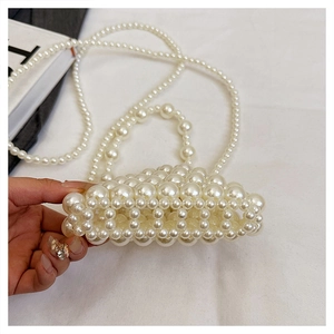 Gros plan d'un mini sac tissé en perles fait main avec un motif ajouré très raffiné