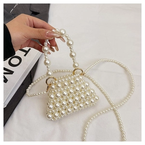 Détail d'un mini sac à perles fait main avec anneaux dorés et bandoulière en perles