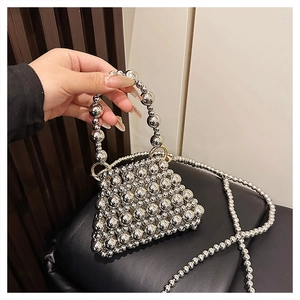 Détail d'un mini sac à main argenté perlé avec finition métallique et longue bandoulière