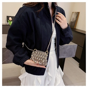 Détail d'un mini sac perlé argenté artisanal avec fine chaîne en métal et texture tressée