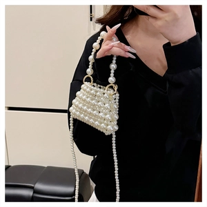 Détail du mini sac à main tissé en perles blanches avec anneaux en métal doré