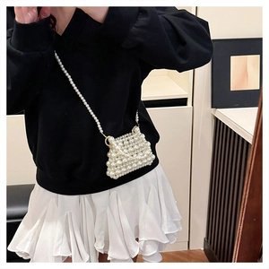 Détail du mini sac bandoulière en perles porté par un mannequin avec texture élégante