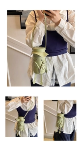 Detail view of light green cylinder crossbody bag in creative jacket design with mini legs