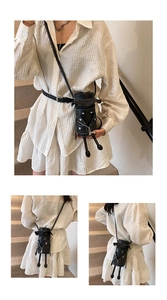 Detail of mini black crossbody bag featuring a unique 3D biker jacket design with tiny legs
