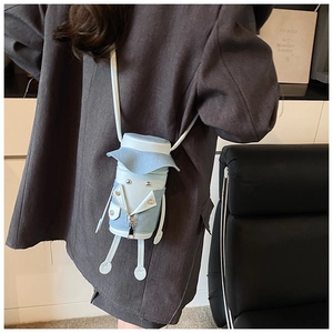 Close-up of mini cartoon crossbody bag with light blue denim patchwork and biker jacket detail