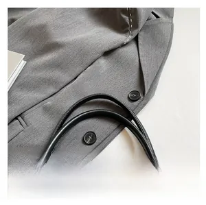 Detail of gray snakeskin shoulder bag showing comfortable straps and black buttons