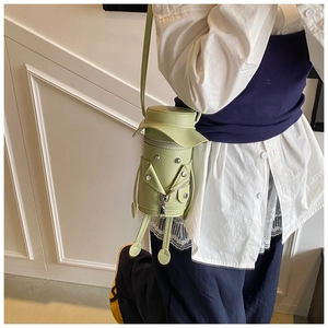 Detail of light green cartoon character crossbody bag showing the unique doll-shaped design