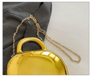 Detail of the elegant gold metallic chain strap on a glossy candy-colored shell bag