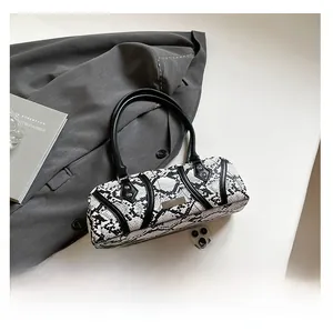 Detailed view of snake skin pattern handbag with black leather trim and silver logo