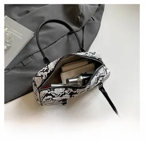 Detail view of large capacity snakeskin pattern shoulder bag with interior essentials