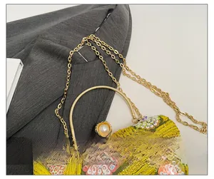 Macro view of gold sequins and floral beadwork on the evening bag with pearl clasp