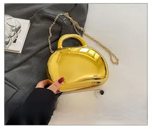 Detail view of gold bean-shaped shell bag with metallic mirror finish and chain strap