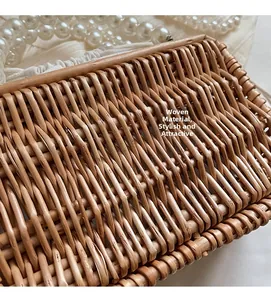 Detailed view of woven straw material with white fabric lining and pearl handle accents