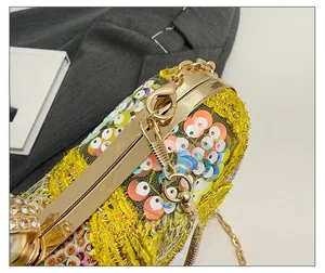 Close-up of shimmering sequins, rhinestone clasp and gold metal frame of evening bag