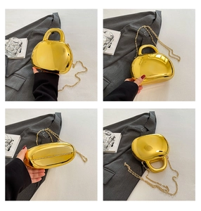 Detail view of glossy gold metallic shell bag showing handles and chain strap