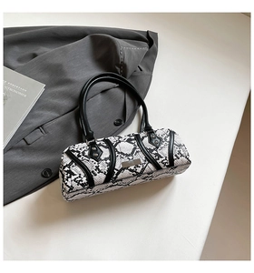 Close-up of stylish black and white snakeskin Boston bag with premium leather handles