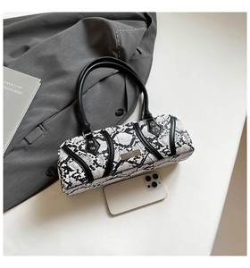 Detail of snake skin pattern pillow bag with smartphone for size reference and metal plate