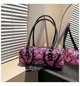 Macro detail of snakeskin print texture on fuchsia Boston bag with metallic logo
